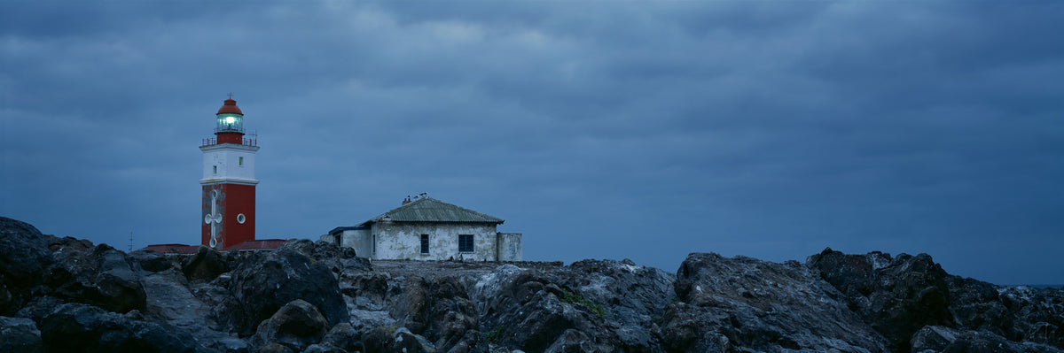 Bird Island Lighthouse by Koos van der Lende, the lighthouse lit on a cold evening