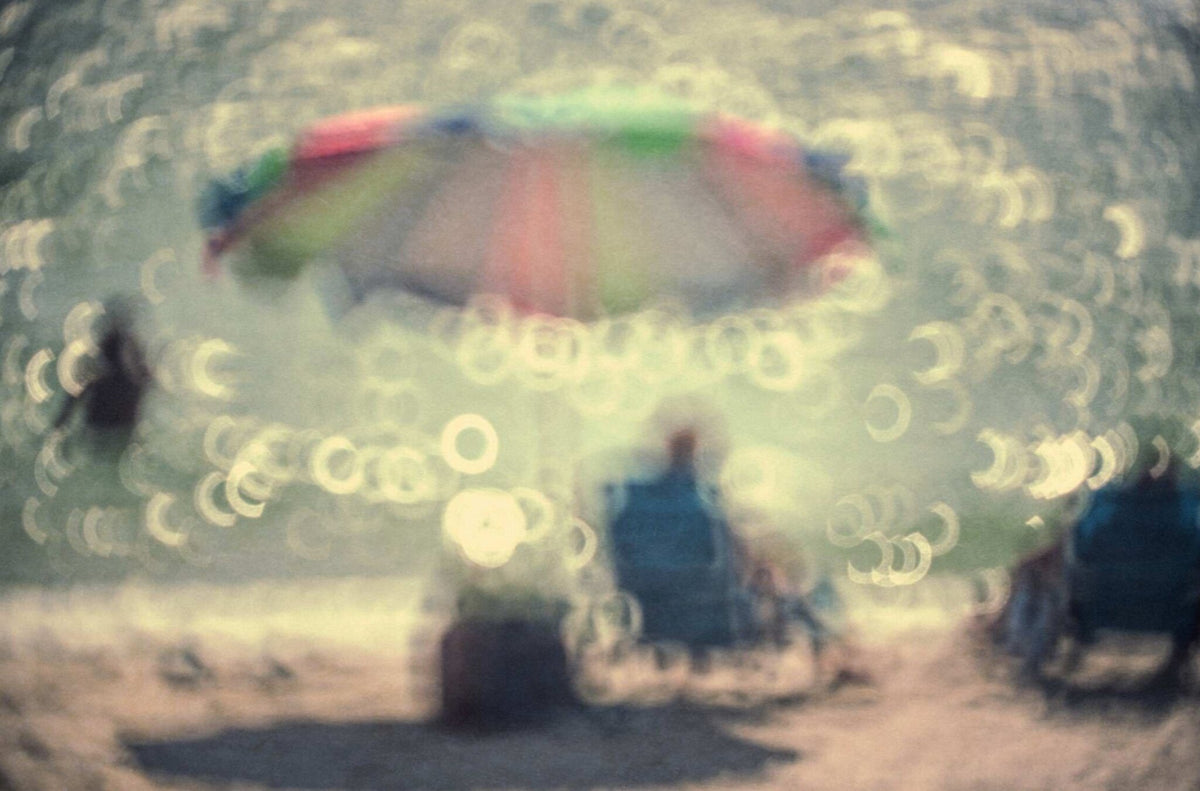 A Man with a Blue Shirt Sitting Under a Pretty Umbrella by Harry De Zitter, a documentary photograph