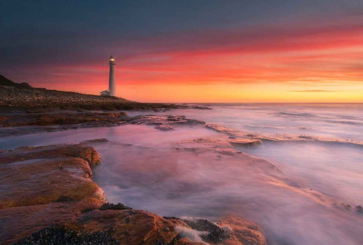 Slangkop Lighthouse by Hougaard Malan, a sunset over the Cape Peninsula