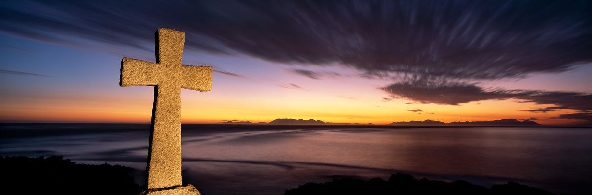 The Cross by Koos van der Lende, a stone memorial cross at dusk over False Bay